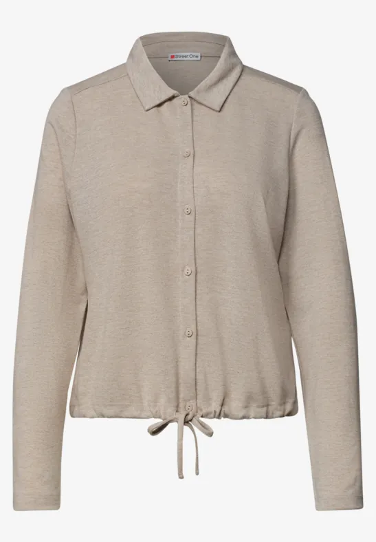 Beige blouse met lange mouwen, kraag, knoopsluiting en trekkoordzoom.