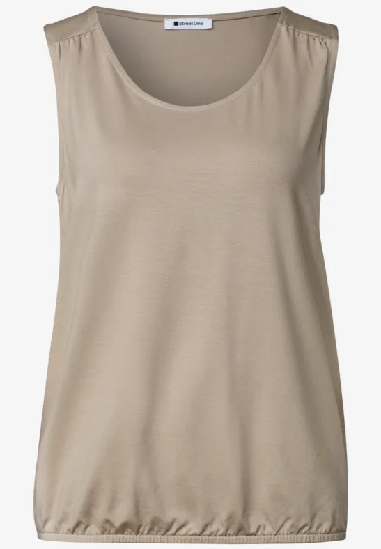 Mouwloos beige topje van licht materiaal, ronde hals en elastische zoom.