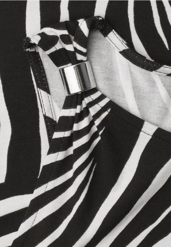 Schwarz-weißer Zebra-Musterstoff mit Falten und silbernem Schiebeverschluss, detailreich.