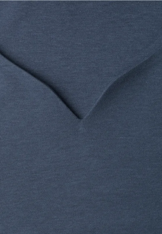 Gros plan d'un T-shirt col en V bleu foncé montrant la texture du tissu.