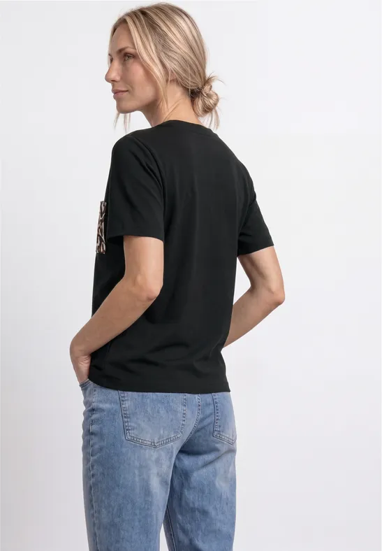 Vrouw van achteren met een zwart t-shirt en een blauwe spijkerbroek.