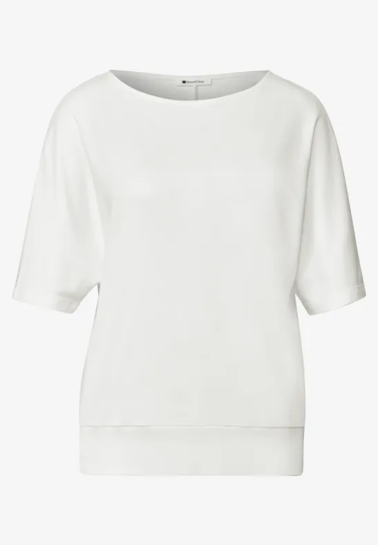 T-shirt blanc ample à manches mi-longues et encolure ronde.