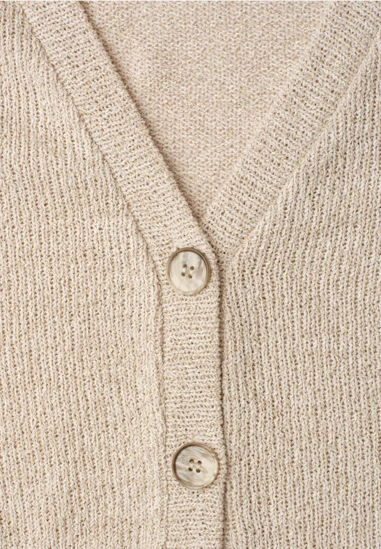 Gros plan d'un cardigan beige en maille épaisse, col V et deux boutons.
