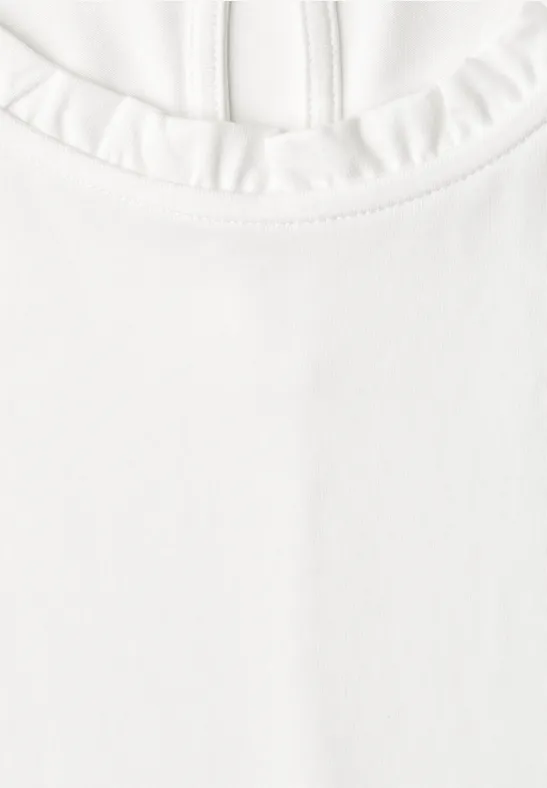 Weißes Shirt mit Rundhalsausschnitt und Rüschenbesatz.
