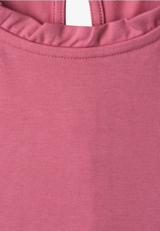Close-up van een roze top met een volantkraag.