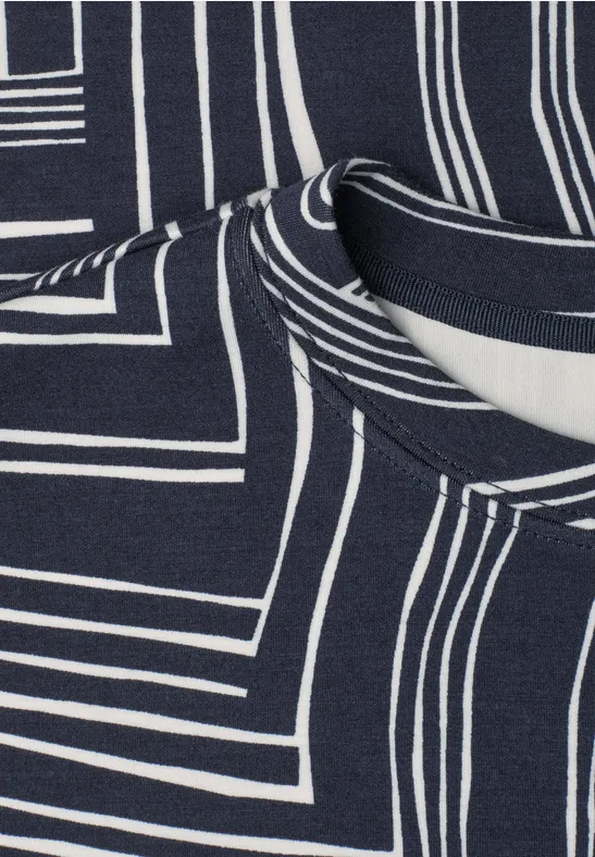 Gros plan d'un tissu bleu marine à motifs géométriques blancs et encolure visible.