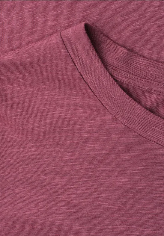 Gros plan d'un T-shirt bordeaux chiné avec col rond.