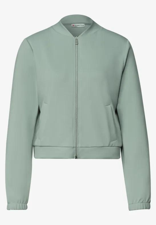 Blouson bomber vert clair avec fermeture éclair, manches longues et poches latérales.