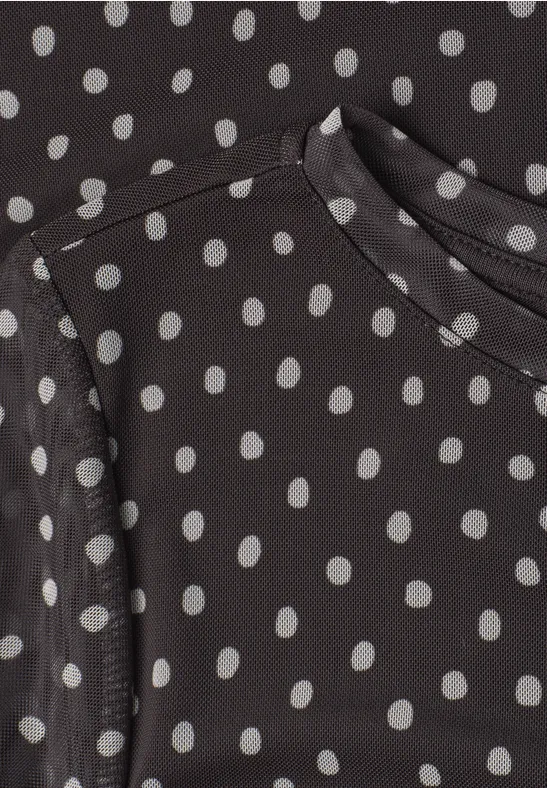 Schwarzes Oberteil mit weißen Polka-Dots und Rundhalsausschnitt.