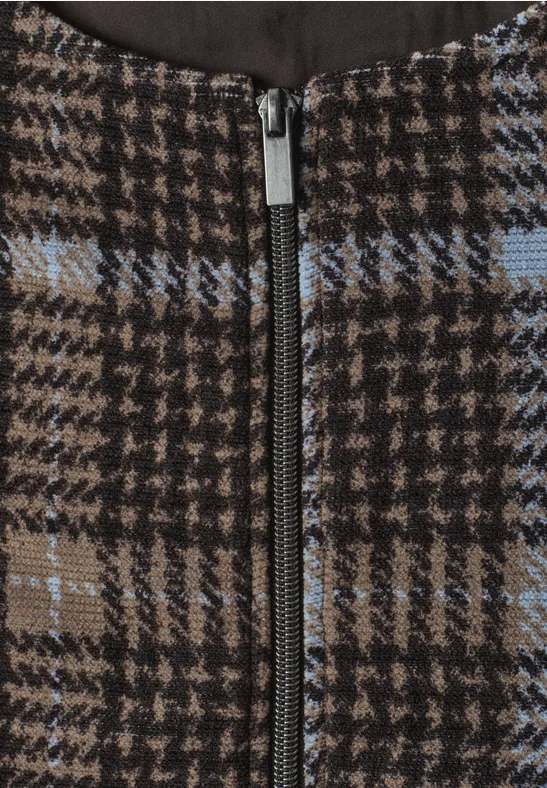 Detailaufnahme eines Hahnentritt-Musters in Braun mit blauen Streifen und zentralem Metall-Reißverschluss.