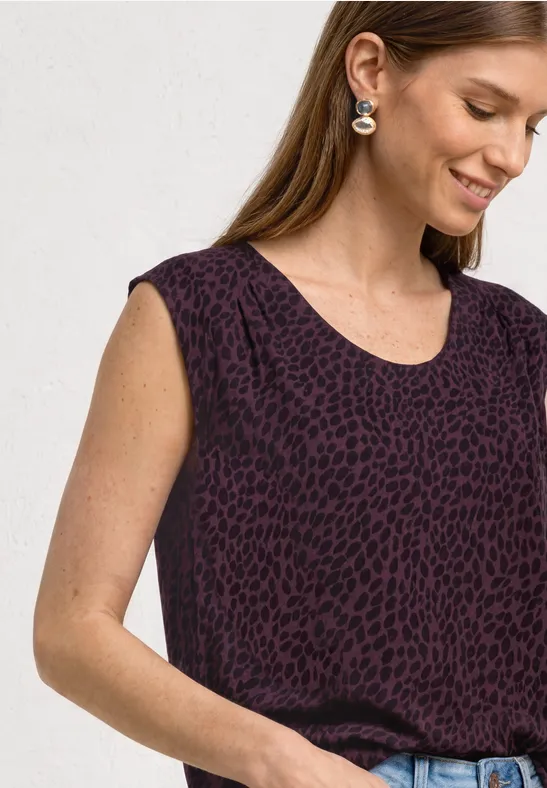 Haut sans manches pour femme, violet foncé avec imprimé animal discret, porté lâchement dans un jean.