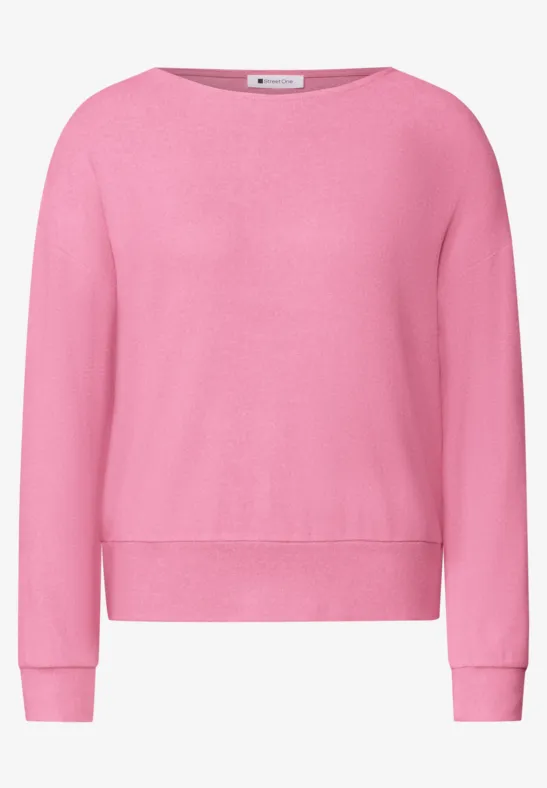 Un pull rose à col rond et manches longues.