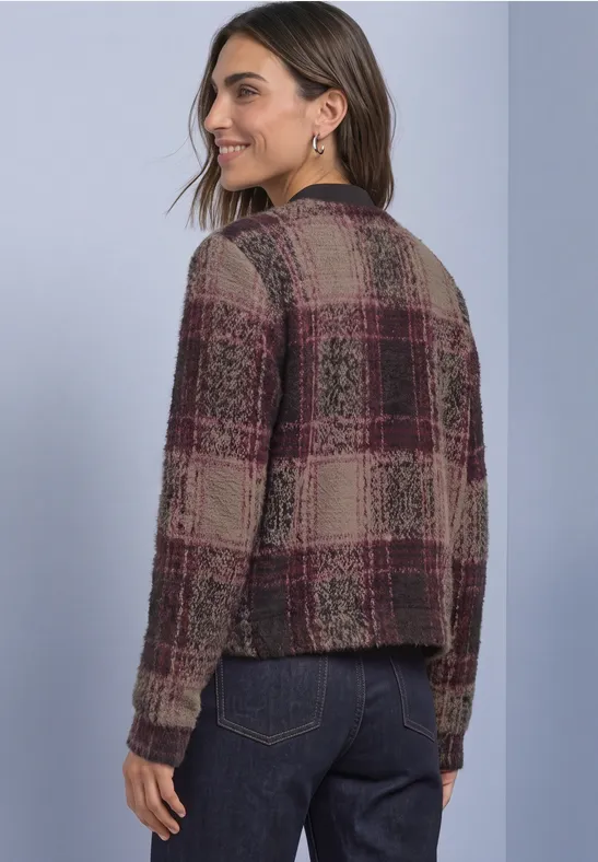 Femme vue de dos portant un cardigan maille à carreaux bordeaux et beige, style décontracté.