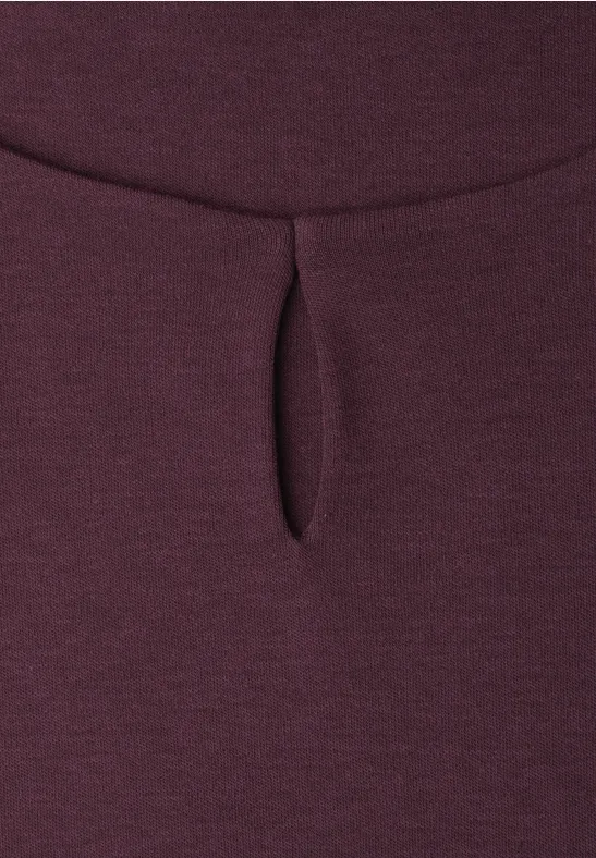 Gros plan sur un tissu bordeaux avec une petite fente verticale