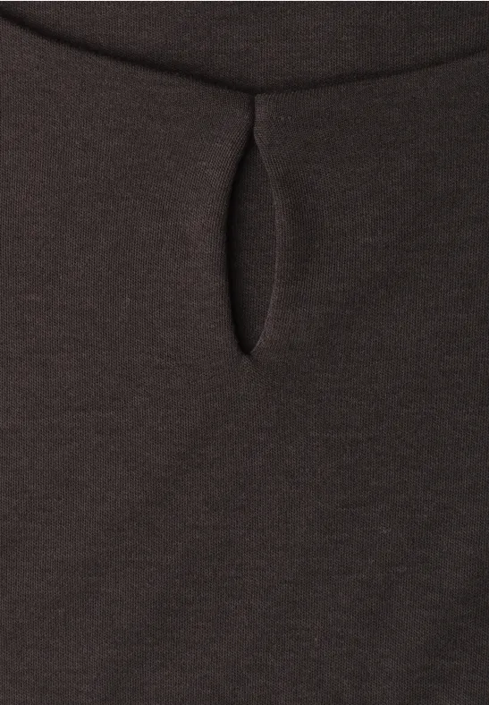 Gros plan sur un tissu foncé avec une petite ouverture verticale.