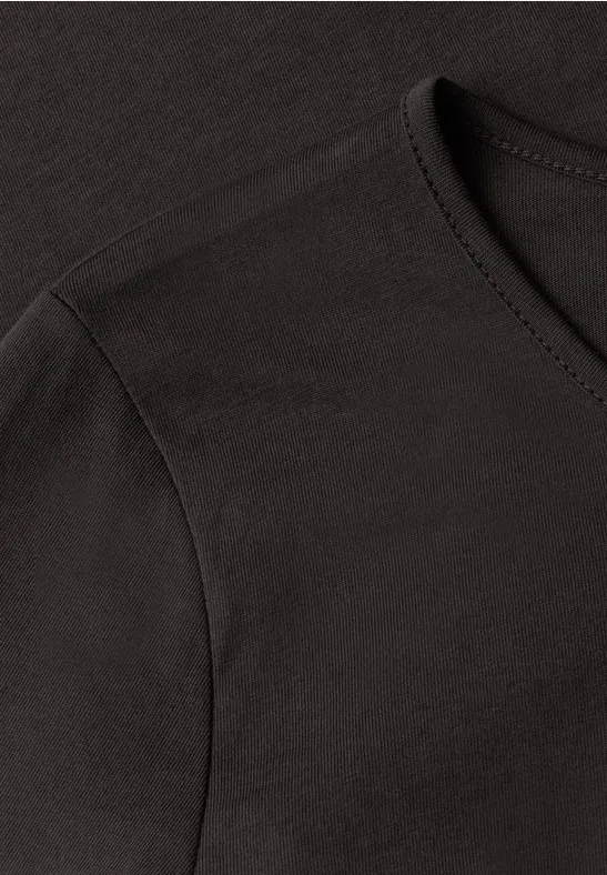Gros plan d’un t-shirt noir à col rond avec couture d’épaule