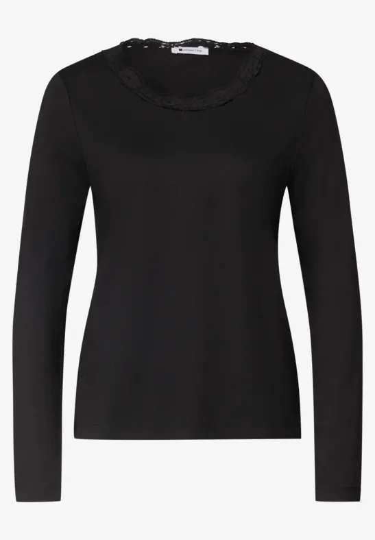 Schwarzes Langarmshirt mit Rüschen- und Spitzenbesatz am Rundhalsausschnitt.