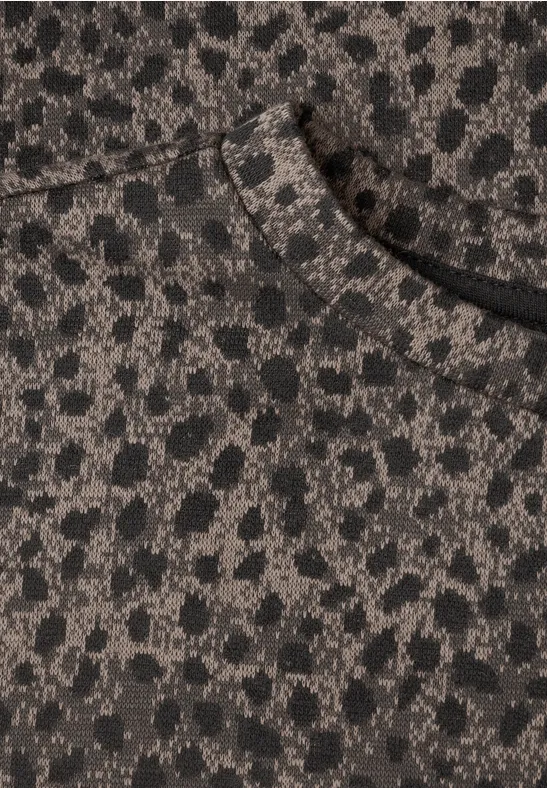 Gros plan sur un vêtement marron-gris à motif léopard avec une poche avant.