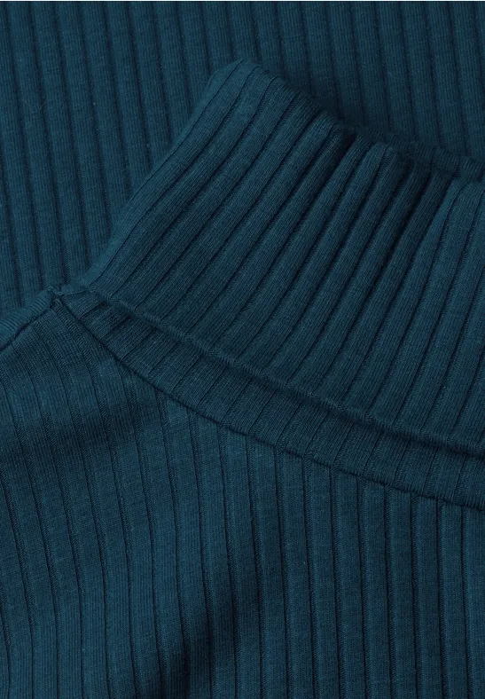 Nahaufnahme eines dunkelgrünen, gerippten Strickrollkragens.