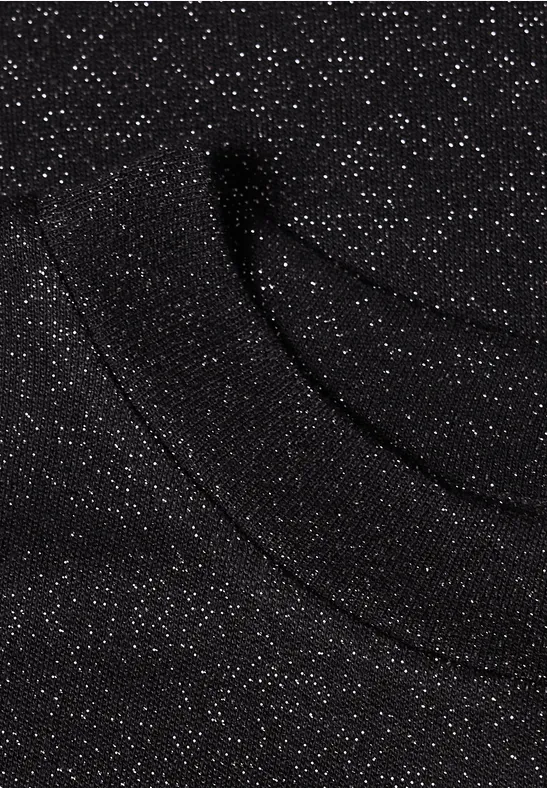 Tissu noir parsemé de paillettes argentées, scintille subtilement et présente un motif onduleux élégant.