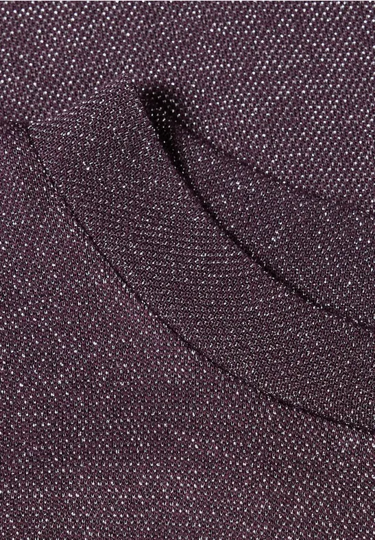 Nahaufnahme eines burgunderroten Strickstoffs mit dezentem Tascheneingriff