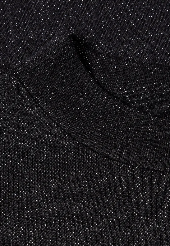 Tissu noir scintillant parsemé de fines paillettes argentées, semblable à un pull ou un t-shirt.