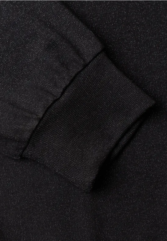 Gros plan sur un poignet de manche noir en tissu tricoté côtelé et élastique.