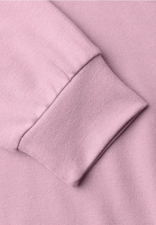 Nahaufnahme eines rosa Sweatshirt-Ärmels mit elastischem Bündchen.