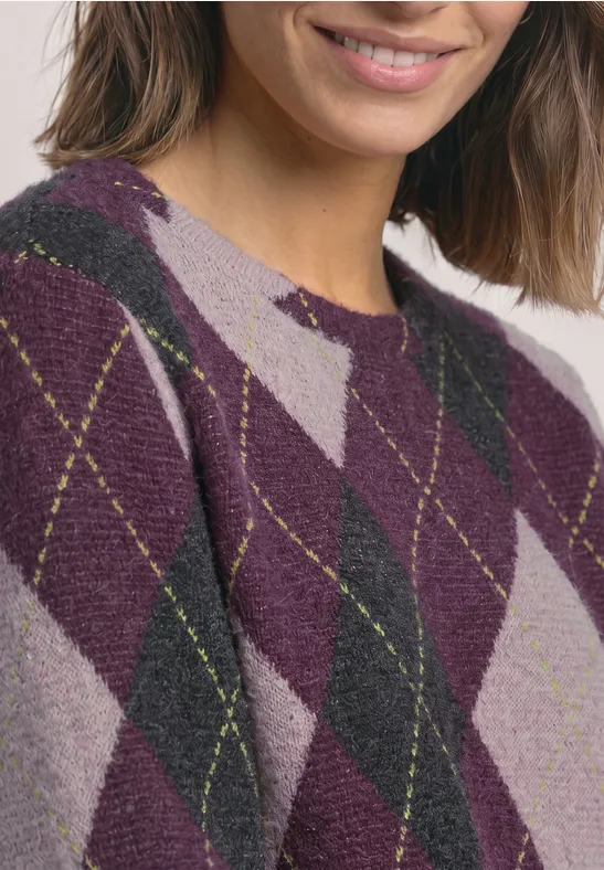 Frau trägt lila-karrierten Pullover mit Rautenmuster.