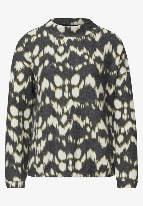 Pull noir et blanc à motif abstrait batik/ikat, col rond et manches longues.