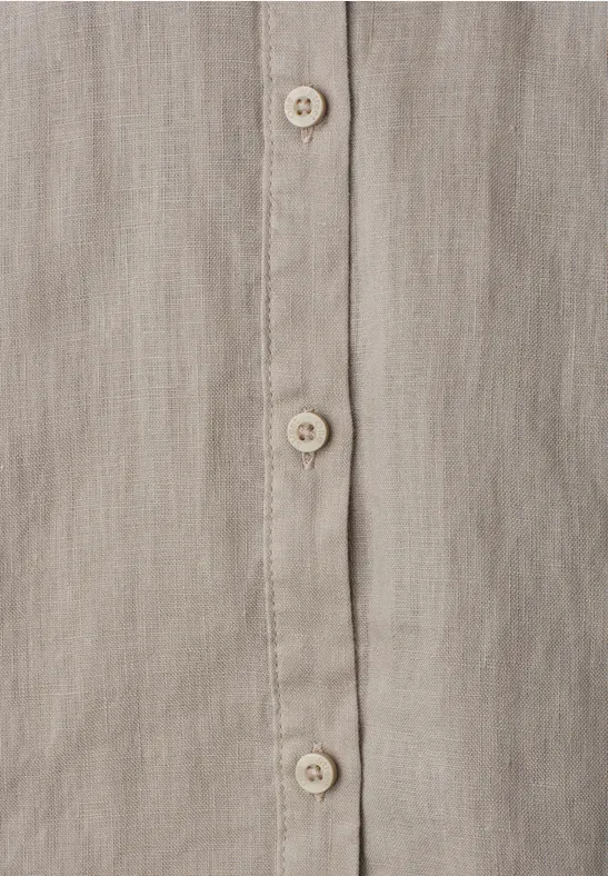 Close-up van een beige-grijs linnen overhemd met knooplijst en crèmekleurige knopen.