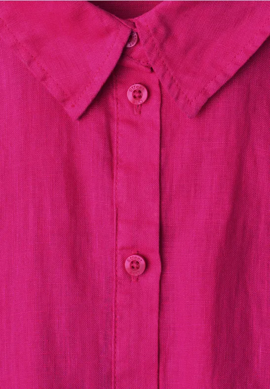 Close-up van een roze overhemd met kraag, knoopsluiting en twee zichtbare knopen.