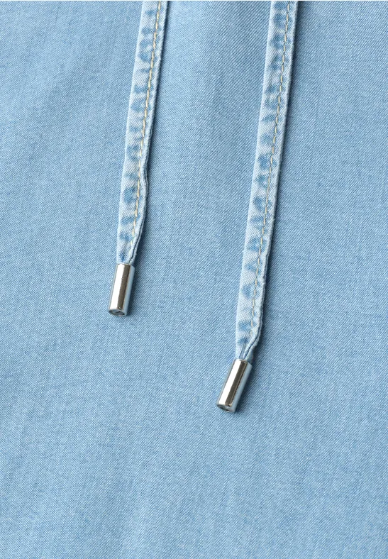 Twee lichtblauwe jeanskoordjes met zilverkleurige uiteinden op lichtblauwe stof