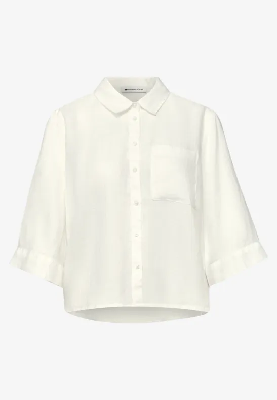 Witte, losse blouse met driekwartmouwen, borstzak en knoopsluiting.