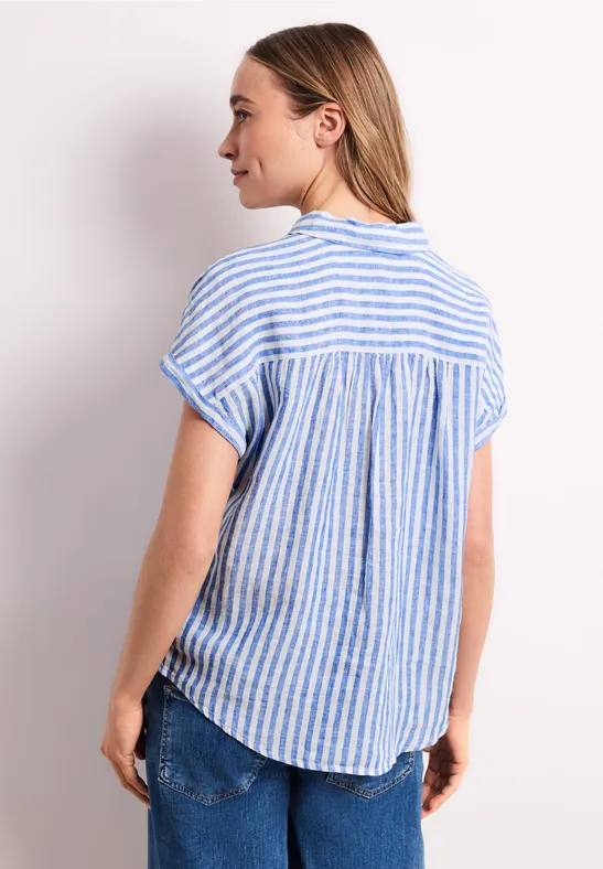 Vrouw van achteren in een loszittend T-shirt met korte mouwen en blauw-witte strepen.