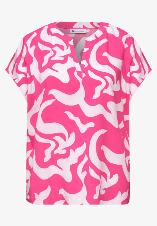 Blouse femme à manches courtes, motif abstrait rose et blanc, encolure fendue.