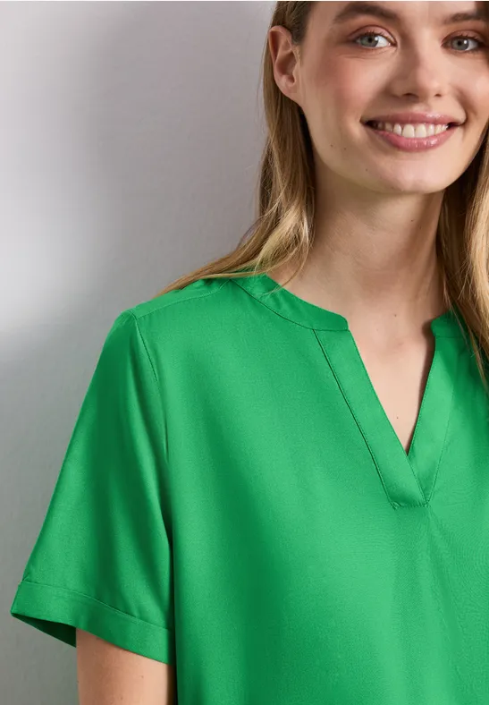 Wazig persoon met een groen shirt voor een neutrale achtergrond.