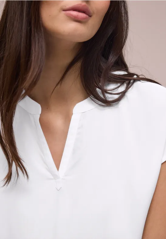 Vrouwelijke torso in een witte blouse met V-hals