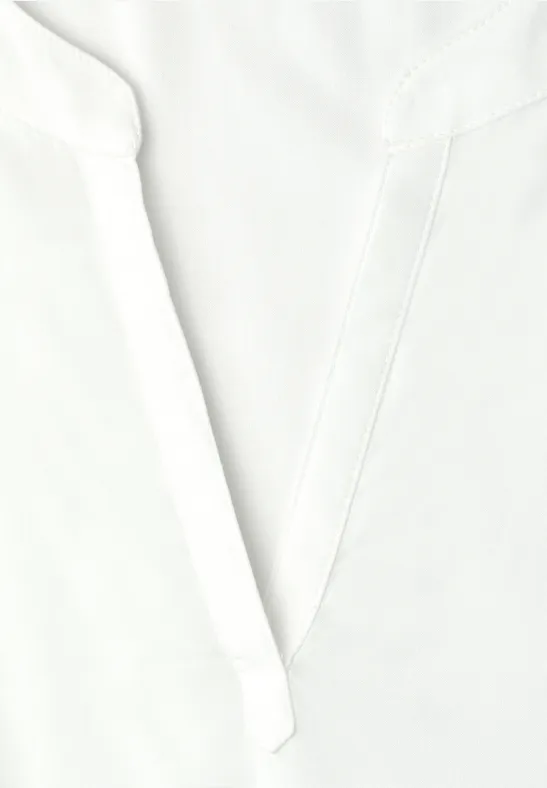 Gros plan sur l'encolure en V d'une chemise blanche