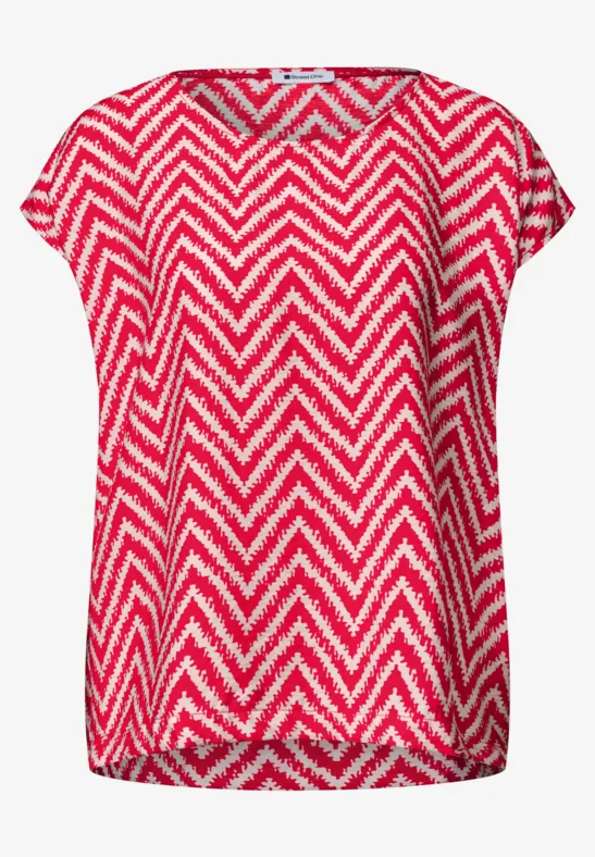 Losvallend shirt met korte mouwen en rood-wit zigzagpatroon.