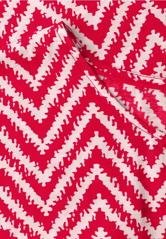 Rood textielpatroon met witte, getande zigzaglijnen