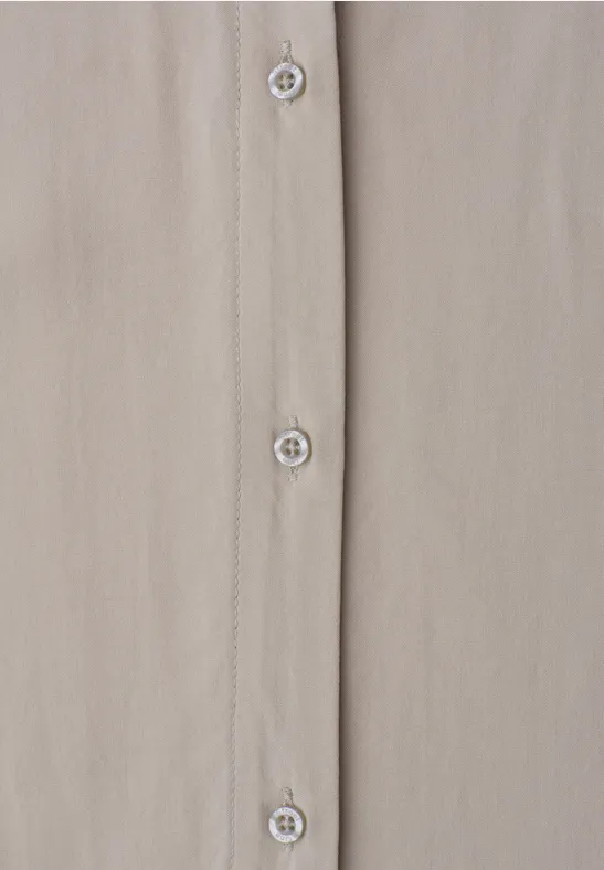 Beige Hemd mit Perlmuttknöpfen, vertikal geknöpft.