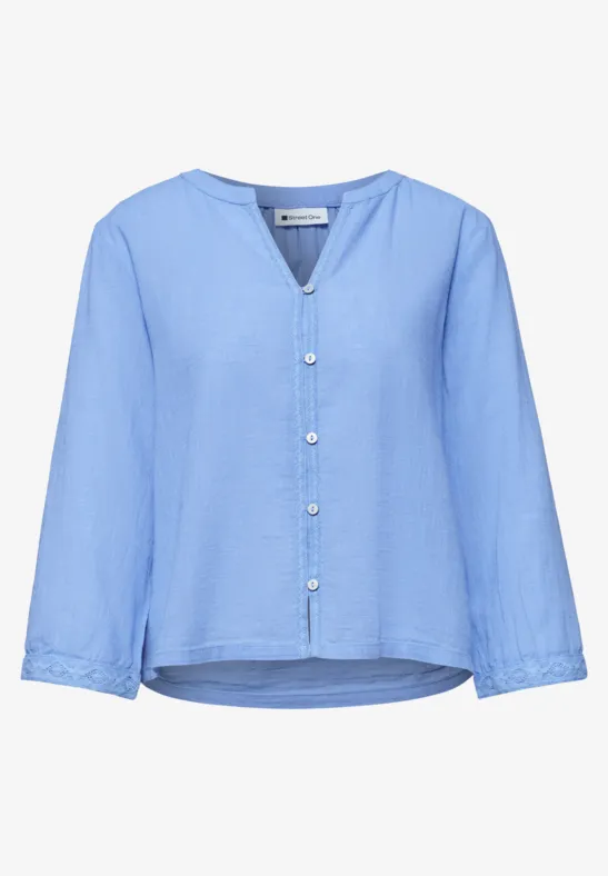Hellblaue, langärmlige Bluse mit V-Ausschnitt, durchgehender Knopfleiste und leicht geschwungenem Saum.