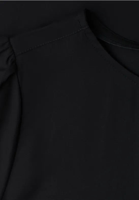 Schwarzes Oberteil mit rundem Halsausschnitt und angedeuteten Puffärmeln