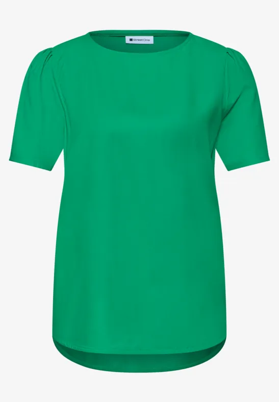 Un t-shirt vert uni à manches courtes, col rond et dos légèrement plus long.
