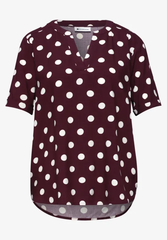 Kurzärmeliges, weinrotes Polka-Dot-Shirt mit weißem Tupfenmuster und V-Ausschnitt.