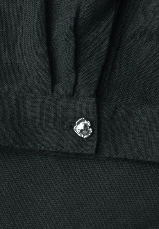 Tissu noir avec un bouton décoratif en forme de fleur serti d’un cristal