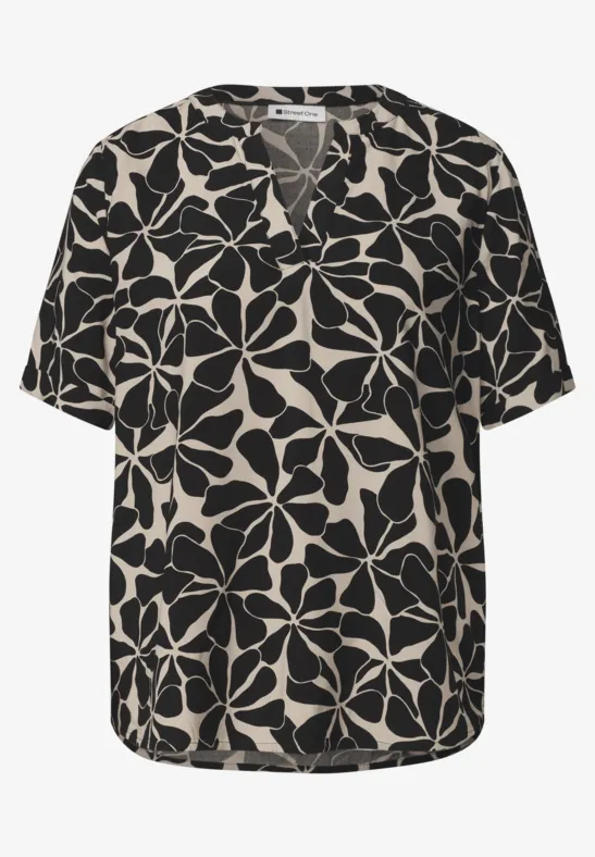 Zwarte top met beige bloemenpatroon, V-hals en korte mouwen.