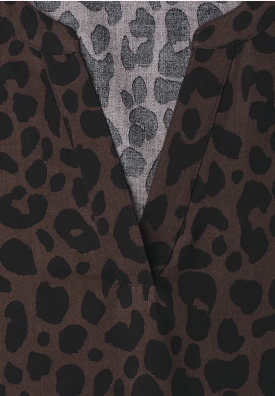 Close-up van kleding met bruin-zwart luipaardprint en grijze voering met zwarte vlekken.