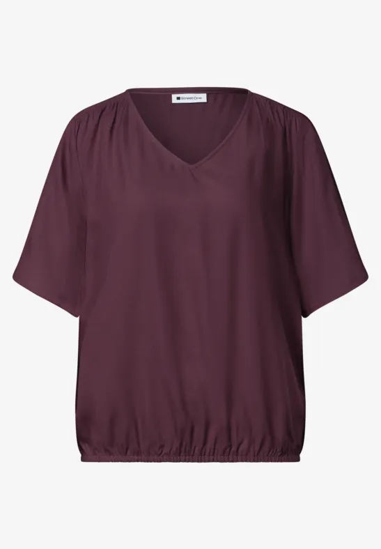 Losvallende bordeaux top met V-hals, korte mouwen en elastische zoom.